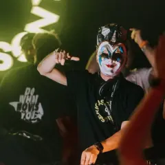 Boris Brejcha w masce klauna na koncercie w Krakowie, wskazujący palcem na tłum.