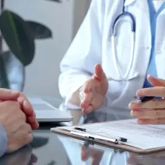Lekarz uspokaja pacjenta z kancerofobią, tłumacząc wyniki badań.