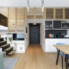 Ingénieuse décoration petit appartement : lit en mezzanine, escalier, cuisine et coin repas optimisés.