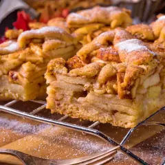 Pyszna szarlotka z jabłkami, idealna do pieczenia na termoobiegu. Posypana cukrem pudrem, czeka na widelce.