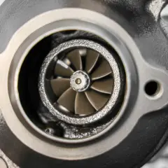 Widok turbosprężarki z widocznym uszkodzonym wirnikiem. Objawy uszkodzonego wirnika turbiny mogą być różne, od utraty mocy po niepokojące dźwięki.