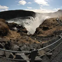Wodospad Gullfoss na Islandii. Tłumy turystów podziwiają potęgę natury, tworząc malowniczy ruch drogowy na ścieżkach.