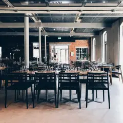 Rader av dukade bord med svarta stolar i en modern lokal. Kanske är det här the picts bar ligger, redo för kvällens gäster.