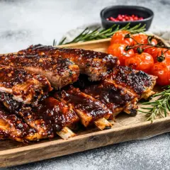 Soczyste żeberka w sosie barbecue, podane z pieczonymi pomidorkami i rozmarynem. Idealne danie, gdy zastanawiasz się, co zrobić z ugotowanych żeberek.