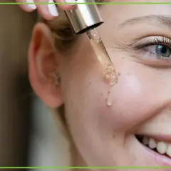 Kropla serum z pipety ląduje na policzku. Czy retinol to witamina A? Tak, to pochodna witaminy A, kluczowa dla zdrowej skóry.