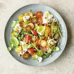 Bunter Tomatensalat mit Burrata, Rucola und Pinienkernen. Ein leichter Genuss für warme Tage.
