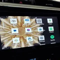 Ekran samochodu z aplikacją Android Auto. Widoczne ikony: Toyota, Kalendarz, Gry, Mapy, Wiadomości, Telefon, Spotify, Ustawienia, Podcasty, Przypomnienia, Messenger.