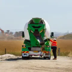 Robotnik przy betoniarce, przygotowuje się do pracy. Cena betonu zależy od wielu czynników.