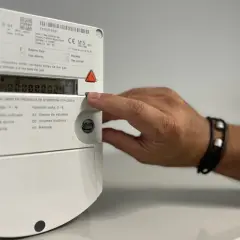 Mano interactuando con un contador digital de gas.