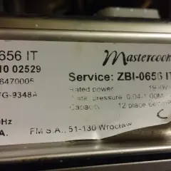 Naklejka z danymi technicznymi kuchenki Mastercook ZBI-0656 IT. Znajdziesz tu m.in. numer seryjny, model FG-9348A, moc 1950W, ciśnienie wody 0.04-1.00M, pojemność 12 kompletów.