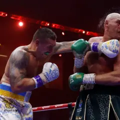 Boxer lands a punch as the referee watches. This intense moment captures the action, and in boxing, "UD" means a unanimous decision win.