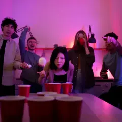 Młodzi ludzie grają w beer ponga, a atmosfera jest pełna śmiechu i zabawy. To idealny moment na pytania do nigdy przenigdy.