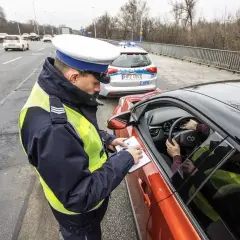 Policjant spisuje mandat. Kierowca zastanawia się, jak się bronić przed art. 97 k.w. w tej sytuacji.