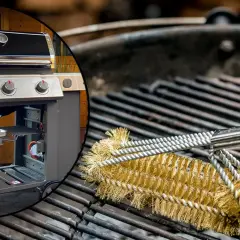 Weber Gasgrill reinigen: Eine Grillbürste aus Messing schrubbt die Roste. Links ist der Grill zu sehen.