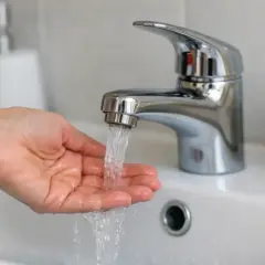 Main tenant se lave les mains sous un robinet d'eau froide. La pression de l'eau est bonne, pas de souci de plus de pression eau froide sur un seul robinet.