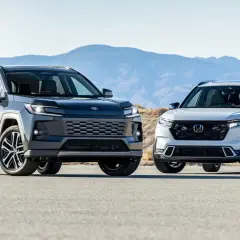 Dwa SUV-y, ciemny i jasny, stoją obok siebie na pustynnym tle. Jasny to nowy model Toyota CRV.