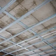 Szkielet metalowy sufitu podwieszanego z widocznymi przewodami elektrycznymi.
