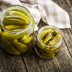 Dos frascos llenos de pepinillos en vinagre. ¡Cuidado! Los pepinillos en vinagre engordan si comes demasiados.