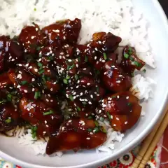 Kyckling i glansig teriyakisås med sesamfrön och gräslök, serverad över ris. Ett enkelt teriyakisås recept att prova.