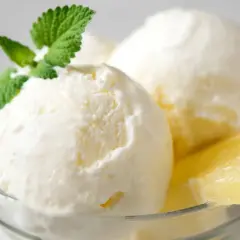 Delicioso helado casero de limón, servido en copa con menta y rodaja de limón. ¡Perfecto para aprender como hacer helado casero!