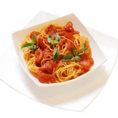Un invitante piatto di spaghetti al pomodoro fresco, guarnito con foglie di basilico verde brillante, pronto per essere gustato.