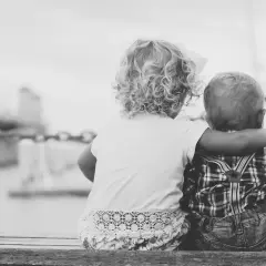 Due bambini, cugini, si abbracciano guardando il mare. Un tenero legame che ricorda un amore puro, lontano da ogni malizia.