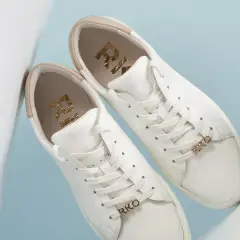 Białe buty sneakersy, co to znaczy? Stylowe, skórzane, z złotymi detalami RKO.