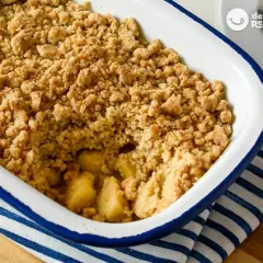 Un delicioso crumble de manzana recién horneado, con trozos dorados de manzana bajo una capa crujiente de migas.