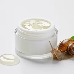 Ślimak obok słoiczka z kremem, symbolizującym naturalne składniki snailmed.