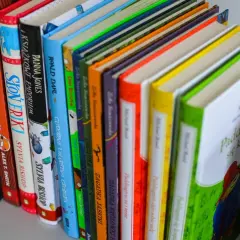 Kolorowe grzbiety książek, w tym "Paddington się krząta", idealne jako książka dla 6 latka chłopca.