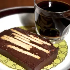 En bit chokladkaka med kex, perfekt för ett radiokaka recept original. Serveras med en kopp kaffe.