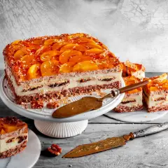 Pyszne ciasto kora dębu z brzoskwiniami i kremem, udekorowane wiórkami kokosowymi. Idealne na deser.
