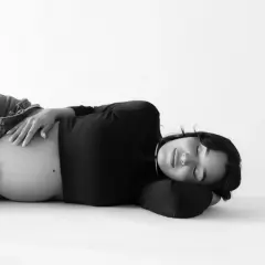 Donna incinta dorme serena, con la mano sul pancione. La vena cava è compressa, ma la serenità della gravidanza prevale.