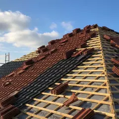 Układanie dachówki na drewnianej konstrukcji. Widać łaty i kontrłaty rozstaw, przygotowane pod pokrycie.