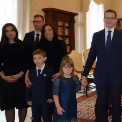 Mateusz Morawiecki z rodziną, w tym z dziećmi w różnym wieku, podczas oficjalnego spotkania.