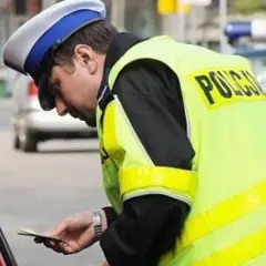 Policjant wręcza mandat. Zastanawiasz się, co jeśli nie zapłacę mandatu w ciągu 7 dni? Lepiej tego nie sprawdzać.