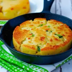 Tortino di patate prosciutto e mozzarella dorato e fragrante, servito in una piccola padella di ghisa.