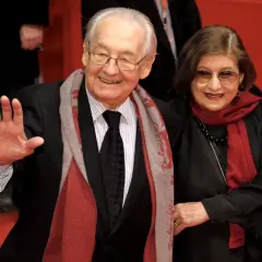 Andrzej Wajda z żoną, Krystyną Zachwatowicz, na czerwonym dywanie. Uśmiechnięci, elegancko ubrani, pozdrawiają publiczność.