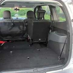 Pusta przestrzeń bagażnika Dacia Lodgy, gotowa na podróż. Widoczne złożone tylne siedzenia i siatka zabezpieczająca.