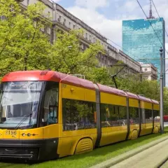 Żółto-czerwony tramwaj na zielonym torowisku. Zastanawiasz się, ile zarabia kierowca tramwaju?