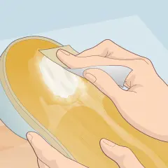 Préparation d'une semelle de chaussure pour la recoller sans colle. Une main frotte la surface avec un papier abrasif.