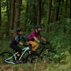 Para jadąca na rowerach górskich przez las. Czy to gravel, czy MTB? Wybór należy do nich.