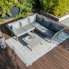 Nowoczesny narożnik i stolik kawowy na drewnianym tarasie. Idealne miejsce na relaks, czyli co to jest patio.