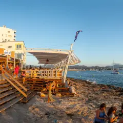 Persone si godono il tramonto sulla costa di Ibiza, vicino alla famosa discoteca Space Ibiza.
