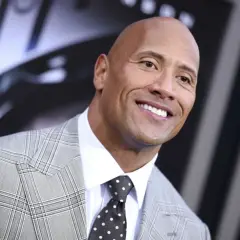 Uśmiechnięty Dwayne "The Rock" Johnson w garniturze. Ciekawe, ile lat ma The Rock, gdy patrzy tak promiennie?