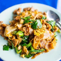 En tallrik med pad see ew, en klassisk thailändsk nudelrätt med breda risnudlar, ägg, grönsaker och kött.
