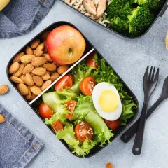 Zdrowe lunchboxy do pracy przepisy: sałatka z jajkiem, pomidorkami i sałatą, jabłko, migdały i ryż z brokułami.