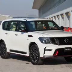 Biały Nissan Patrol Nismo z czerwonymi akcentami stoi na torze wyścigowym.