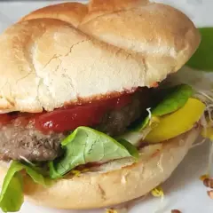 Pyszny burger z soczystym kotletem, sałatą, keczupem i żółtym serem. Idealny przykład, jak usmażyć burgera na patelni.