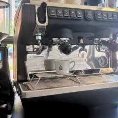 Macchina da caffè professionale con macinacaffè. Pronta per il consumo di caffè, con tazzina in attesa.